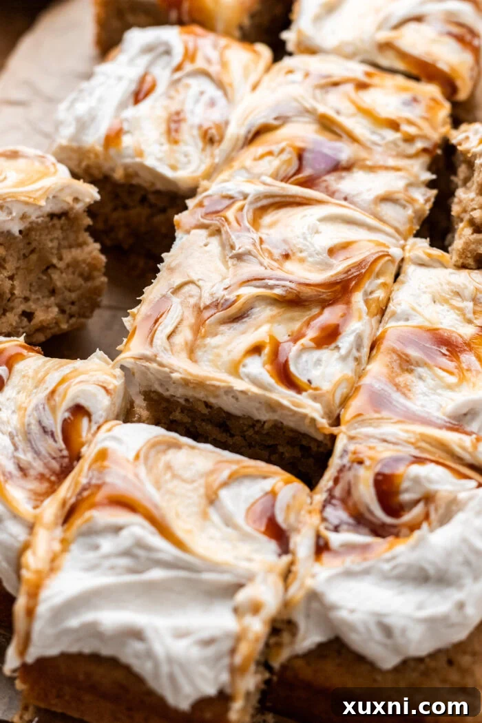 A baked vegan apple caramel cake, beautifully sliced, rests on parchment paper, revealing its moist crumb and tender apple pieces.