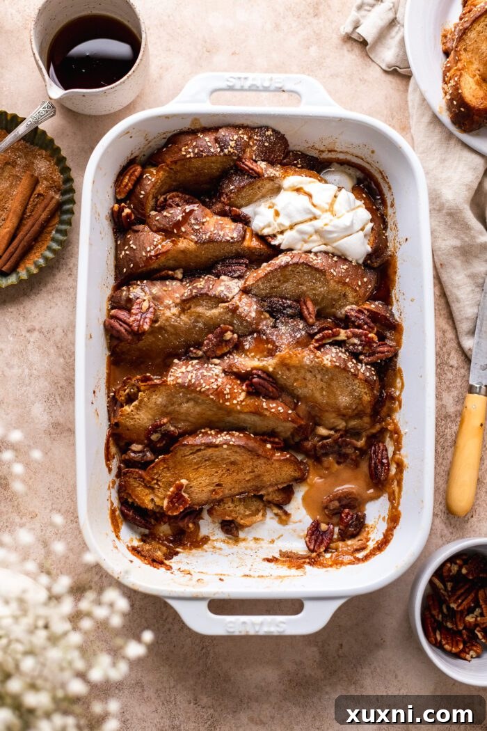 A beautifully served plate of vegan French toast casserole, garnished with fresh fruit and a dusting of powdered sugar.