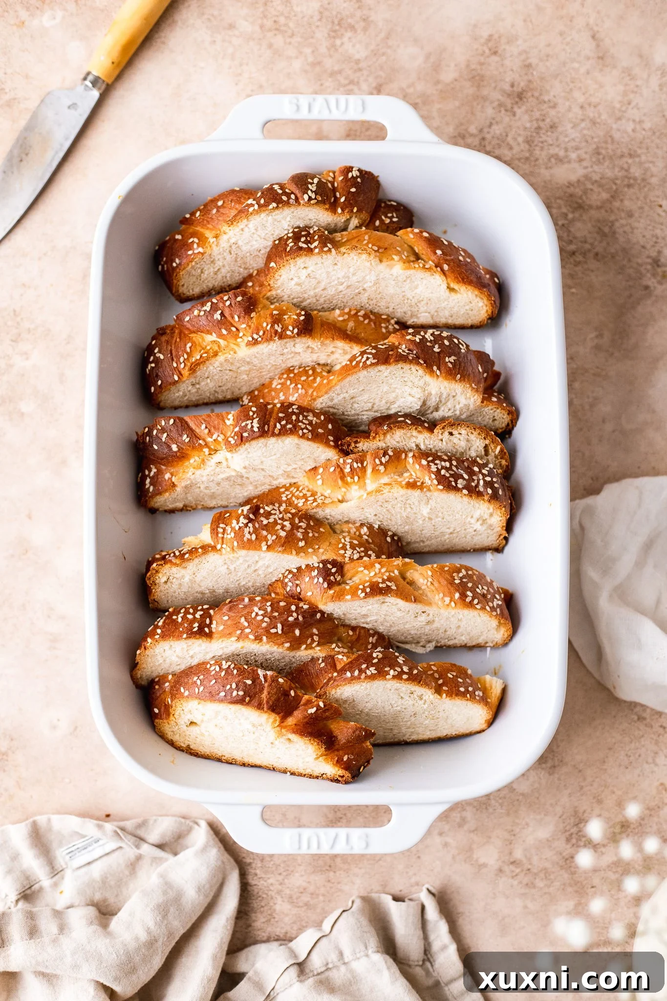 Cubed challah bread soaking in a rich vegan custard mixture in a baking dish.