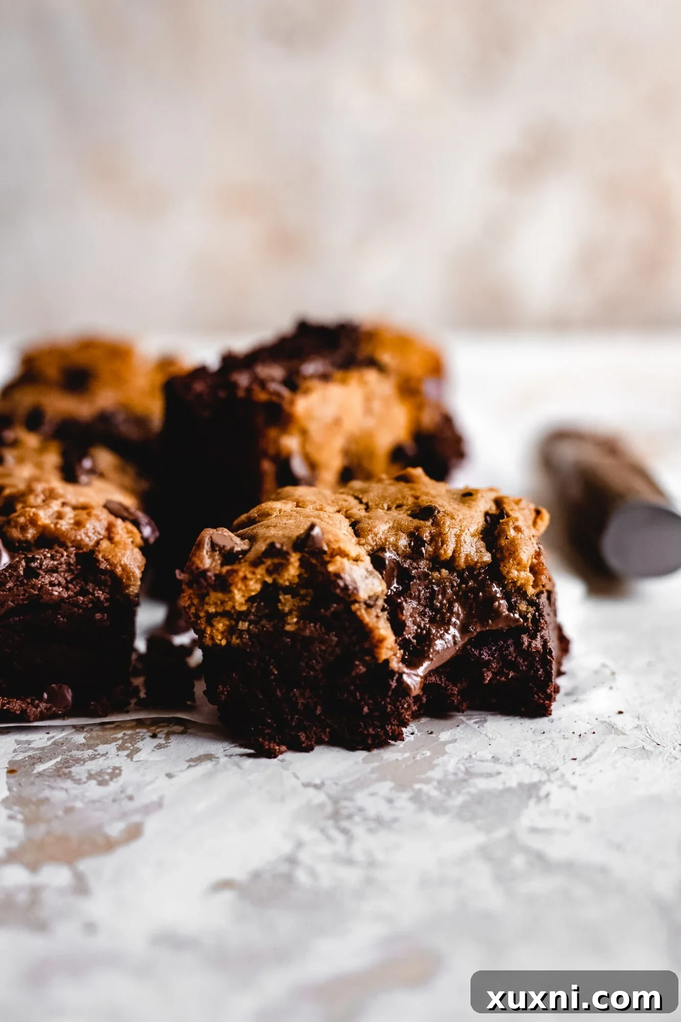 A delicious bite taken out of a vegan brownie cookie bar, showing the soft interior