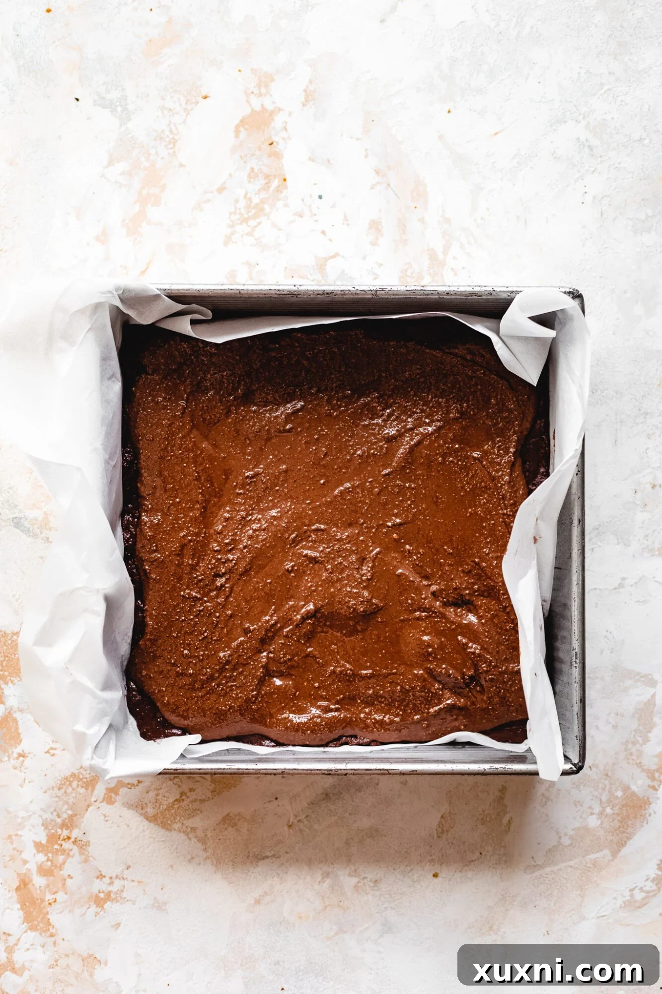 A generous layer of smooth, homemade vegan Nutella spread over brownie batter