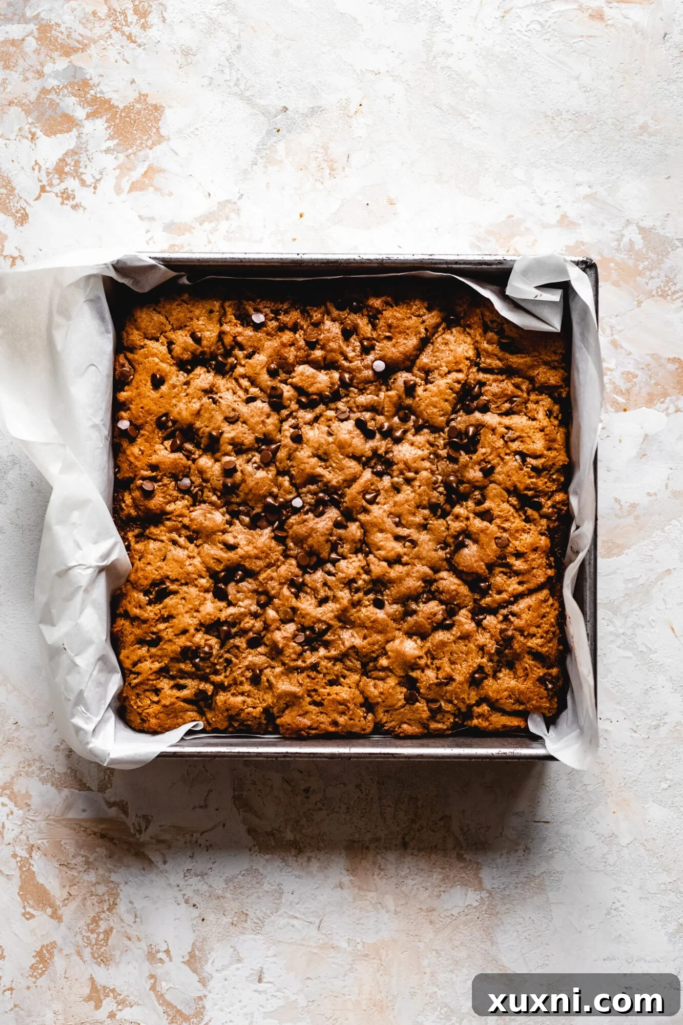 Golden brown baked cookie dough layer on top of the brownie bars