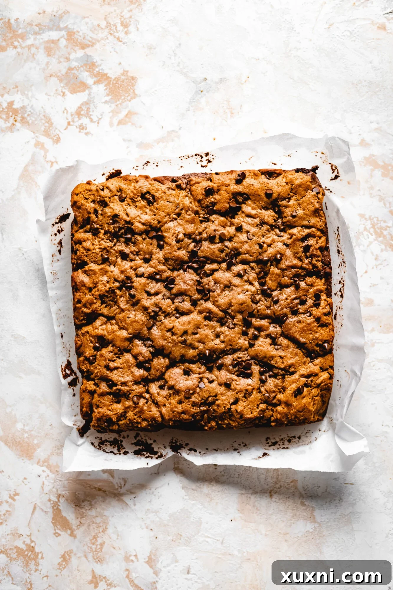 Two halves of a vegan Nutella-stuffed brownie cookie bar, showcasing the layers