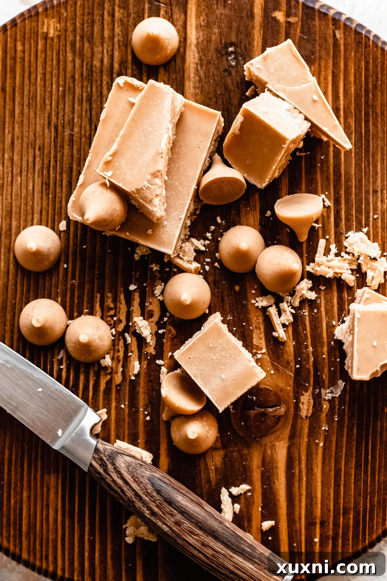 Ingredients for homemade vegan white chocolate, including cacao butter, cashew butter, powdered sugar, and vanilla extract.