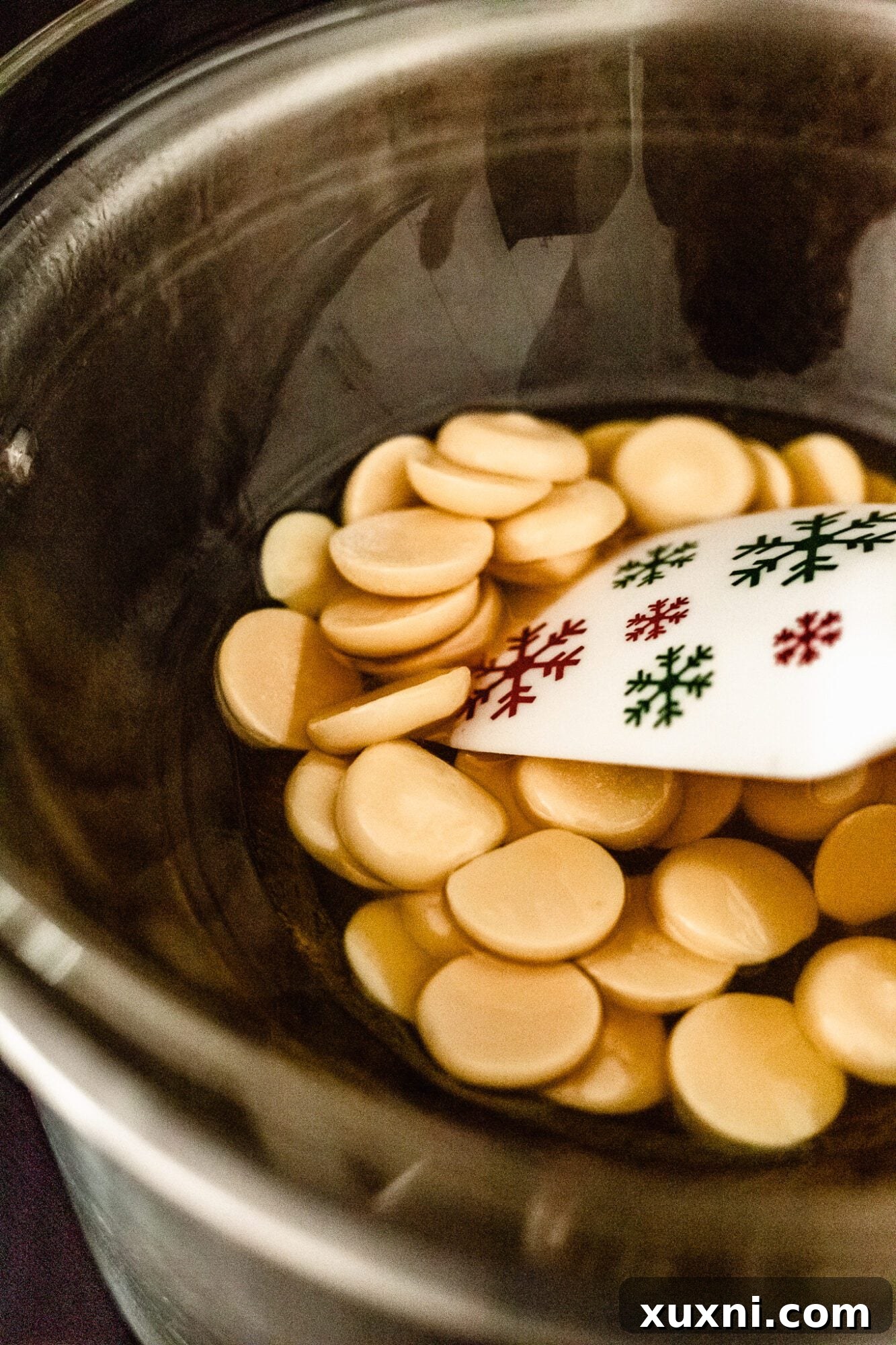 Melted cacao butter in a heat-safe bowl over a double boiler, demonstrating the first step in making vegan white chocolate.