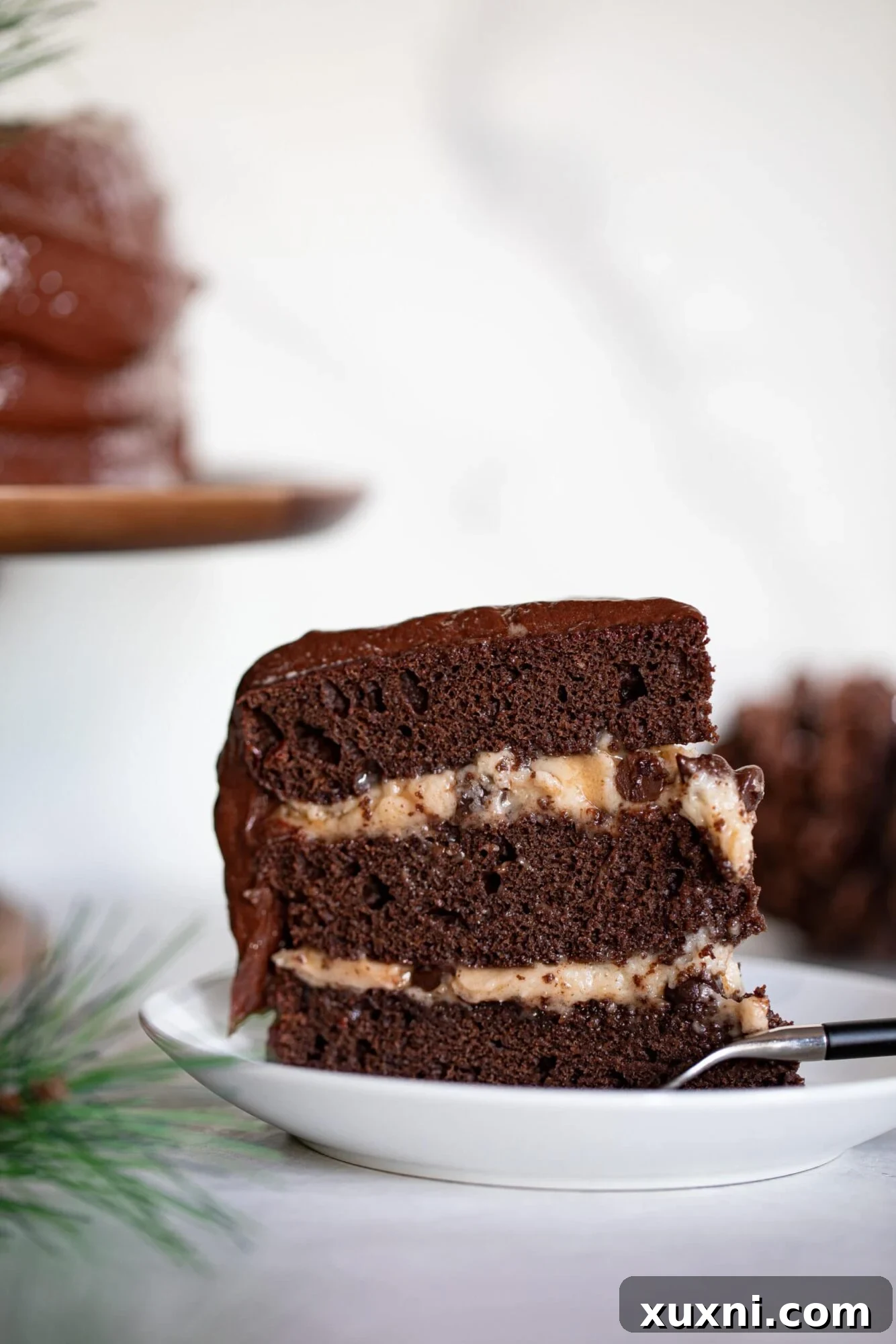 Slice of Vegan Brownie Cookie Dough Cake, showcasing its luscious layers