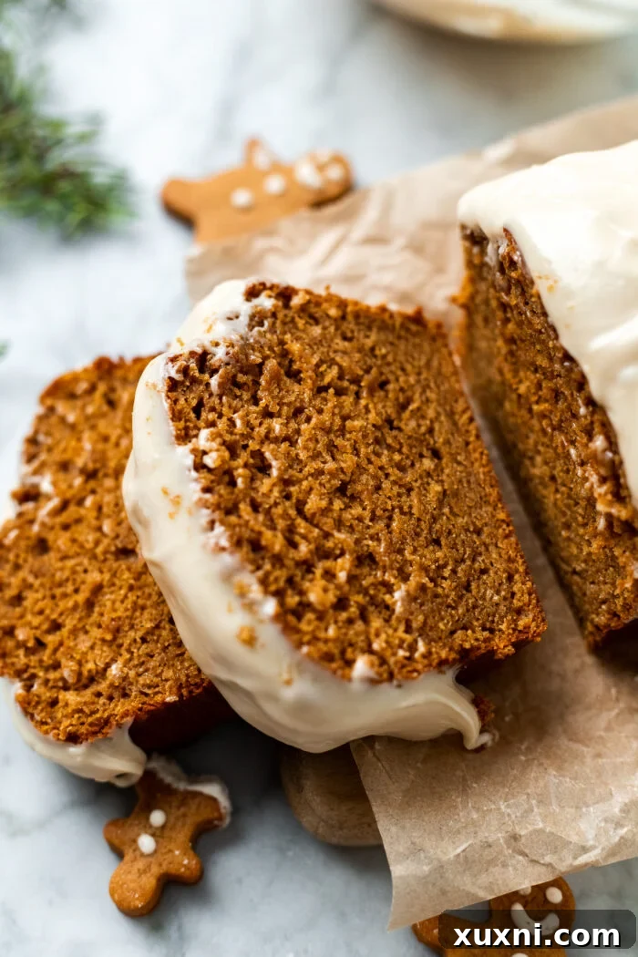 A close-up shot of a single slice of vegan gingerbread loaf cake, rich in color and perfectly moist, highlighting the delicate crumb and inviting texture, ready to be savored.