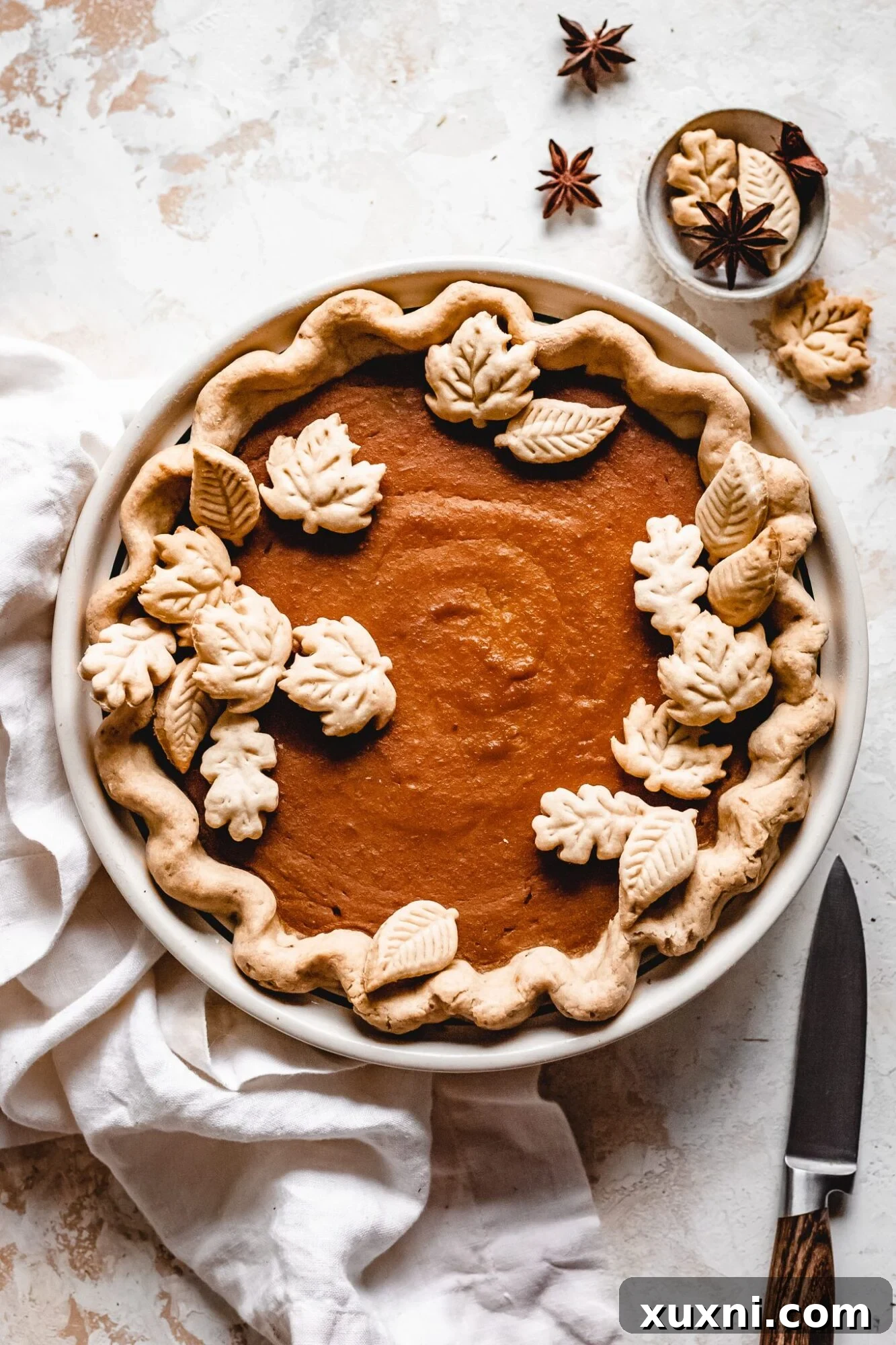 Sliced vegan butternut squash pie, showcasing its creamy filling and golden crust, perfect for Thanksgiving.