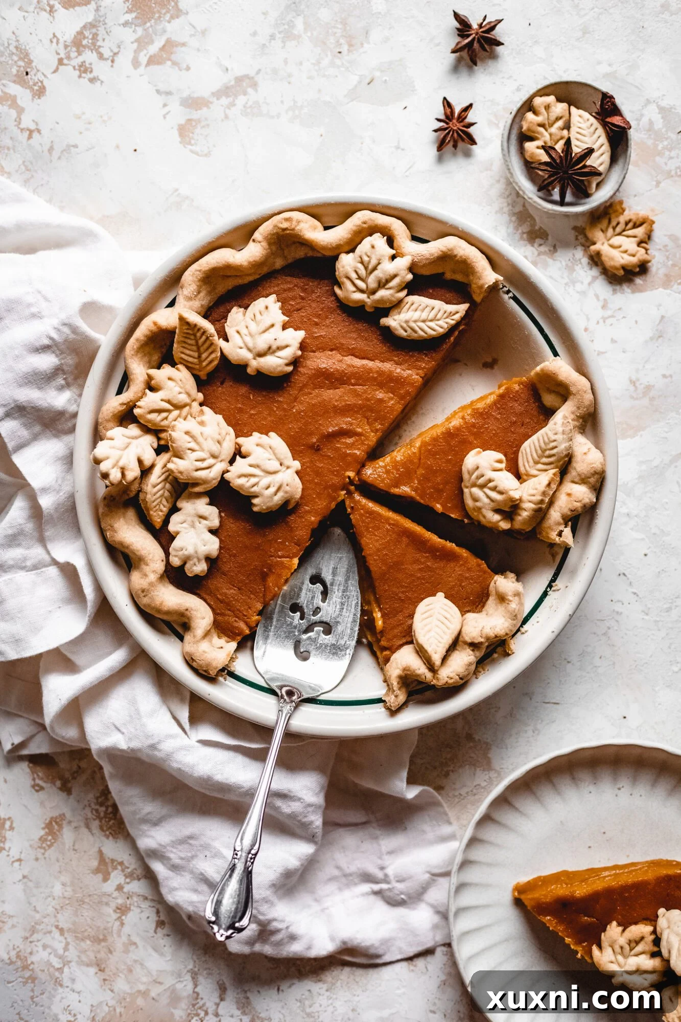 Several whole vegan butternut squash pies cooling on a rack, showcasing their golden-brown crusts.