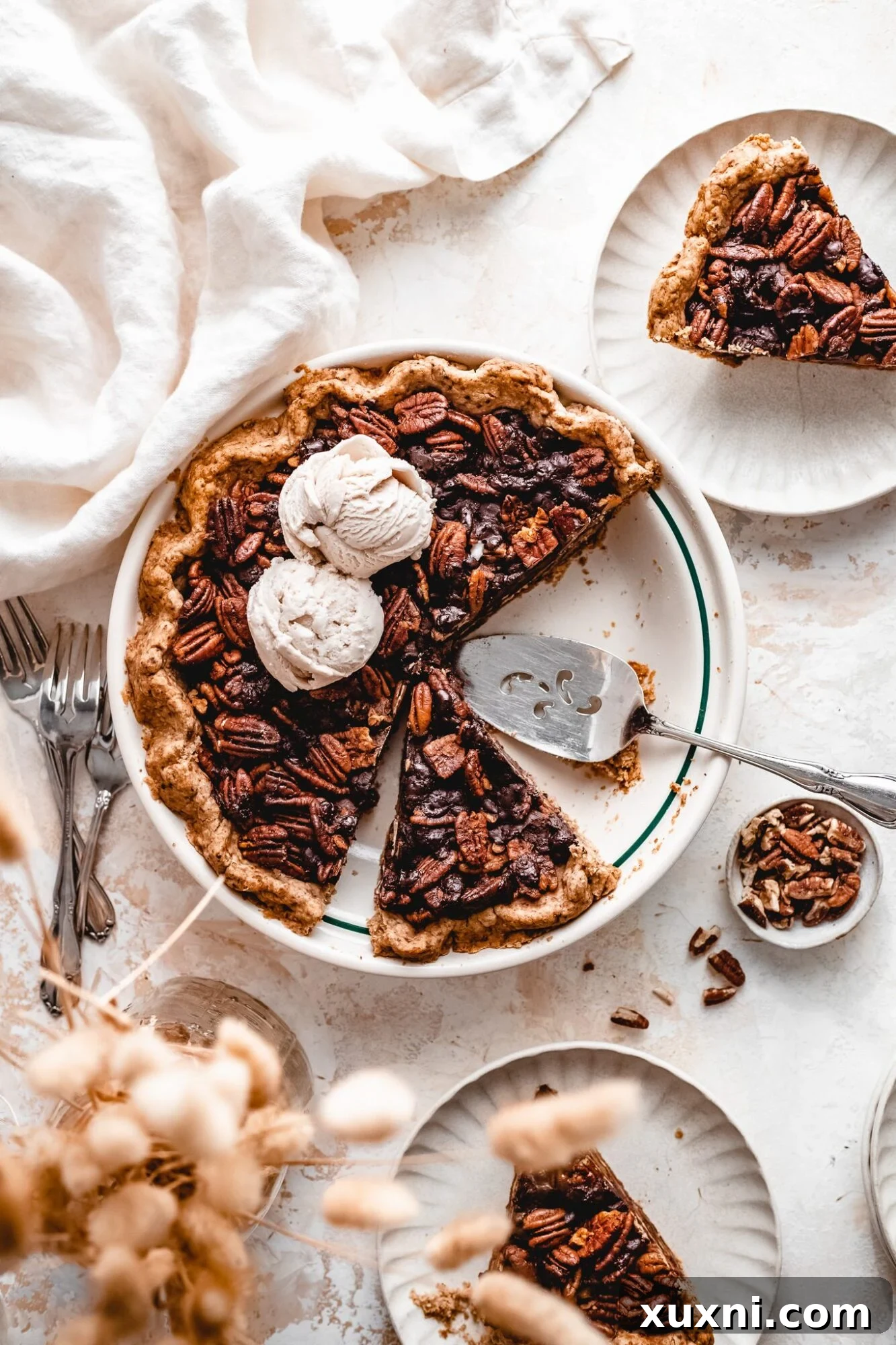 Sliced vegan chocolate pecan pie, revealing gooey filling and toasted pecans.