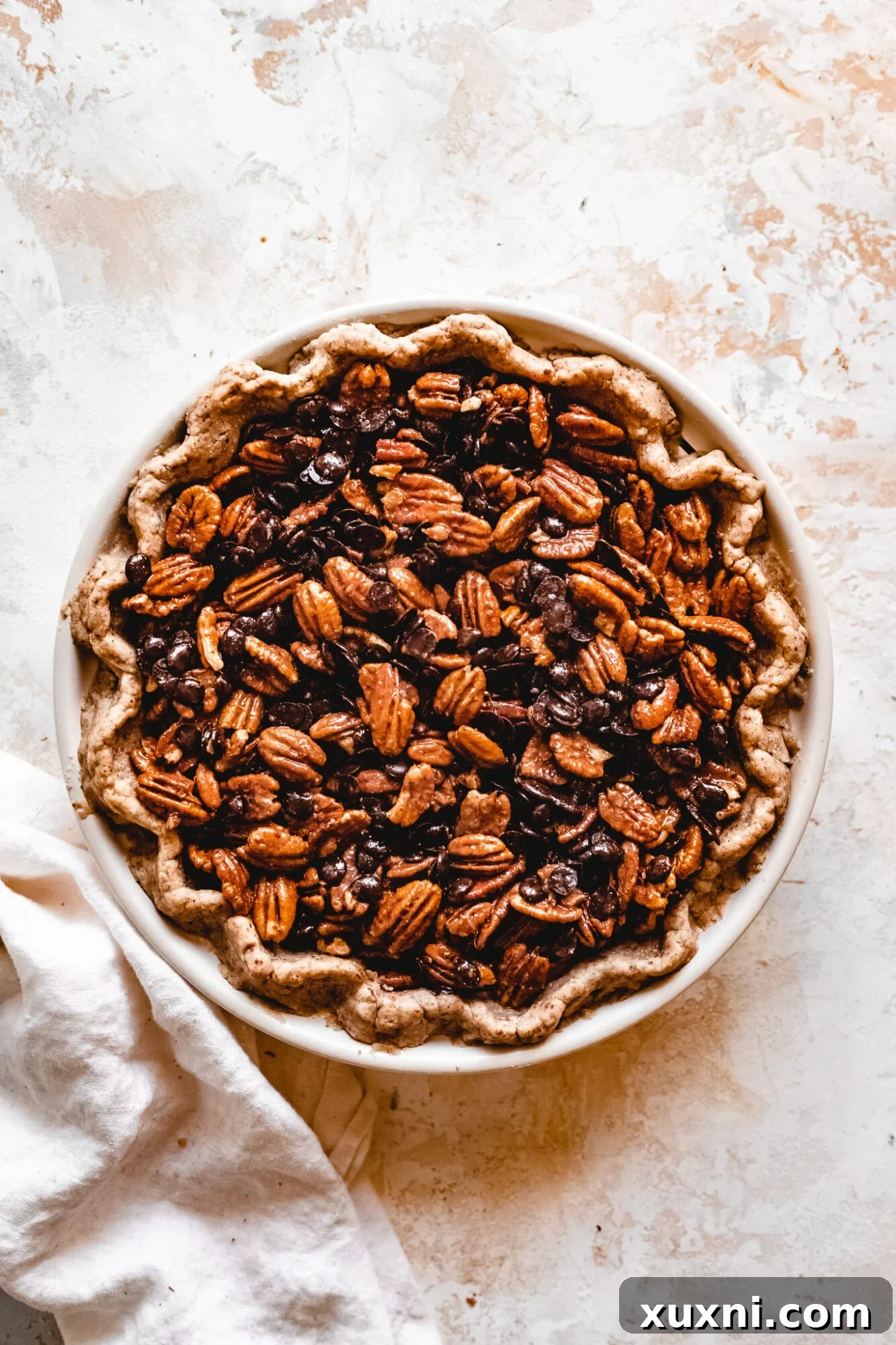 Unbaked vegan chocolate pecan pie ready for the oven.