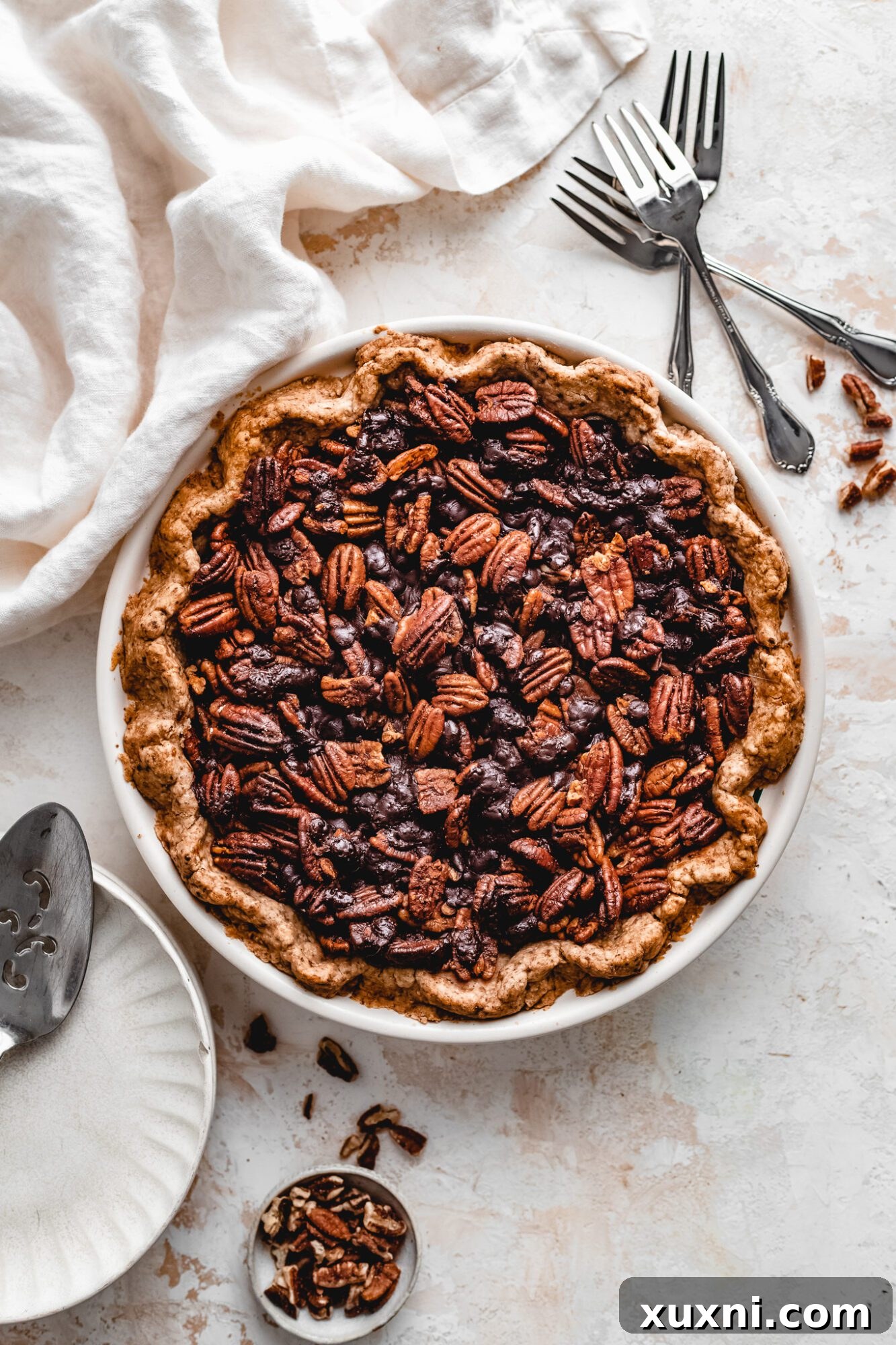 Freshly baked vegan chocolate pecan pie, golden and bubbly.