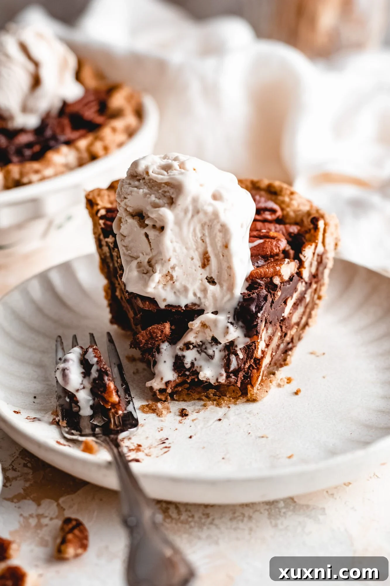 Close-up of a perfectly sliced vegan chocolate pecan pie.