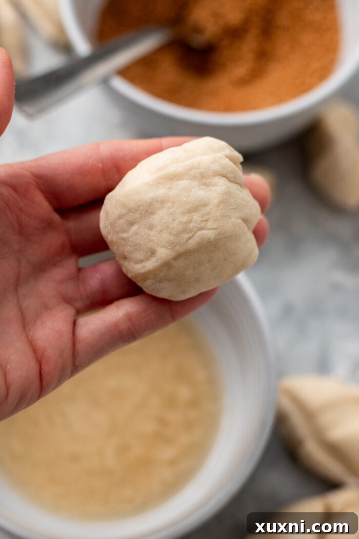 The Ultimate Easy Vegan Pull-Apart Bread 7 A small piece of monkey bread dough being rolled into a smooth ball.