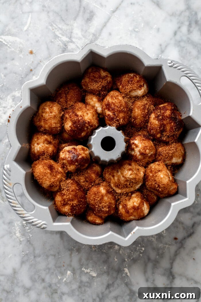 The Ultimate Easy Vegan Pull-Apart Bread 10 Assembled monkey bread dough balls layered in a bundt pan, ready for baking.