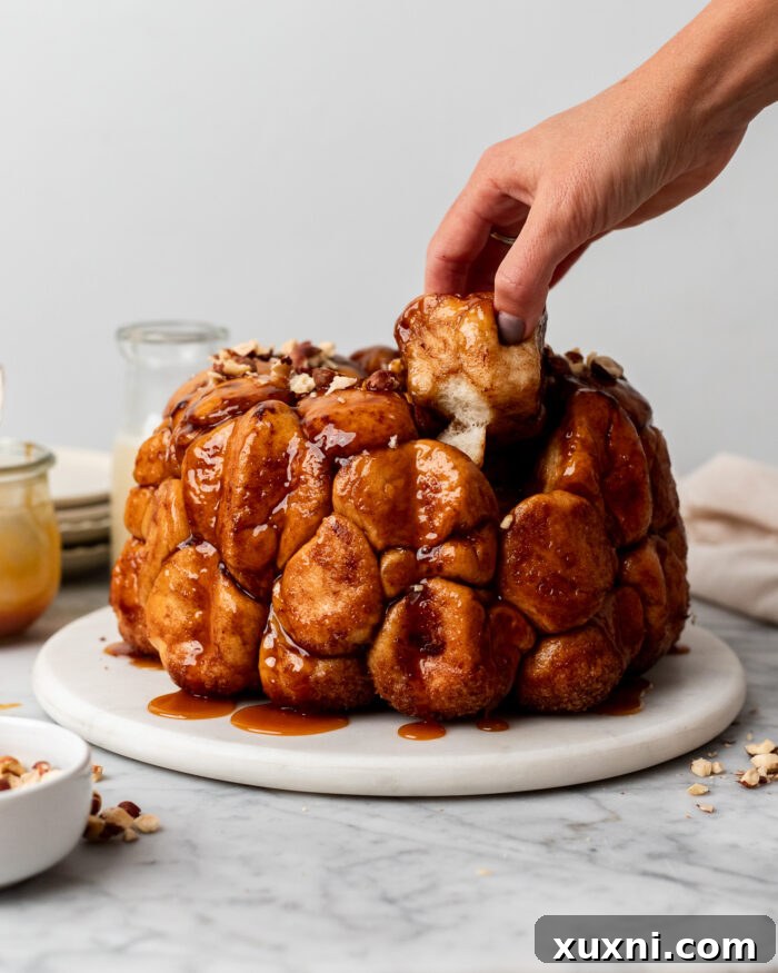 Enjoying Vegan Monkey Bread A hand pulling a piece of vegan monkey bread from the bundt cake.