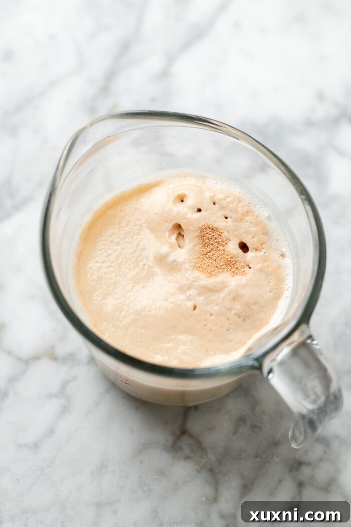 The Ultimate Easy Vegan Pull-Apart Bread 2 Yeast activating in a glass with warm dairy-free milk and sugar.