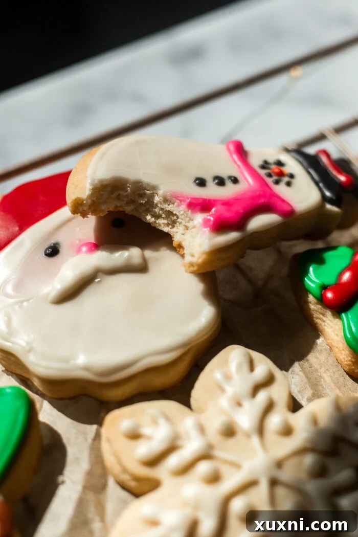 A close-up of a bitten vegan sugar cookie showing its soft, chewy interior texture.