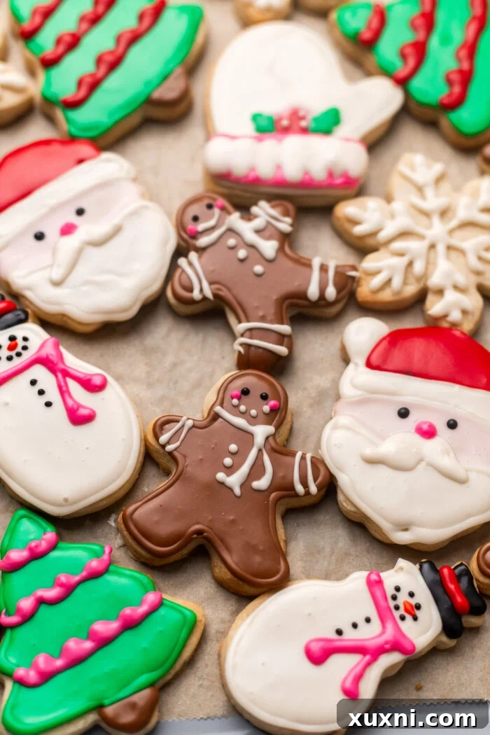 Close up of a hand piping royal icing onto a sugar cookie