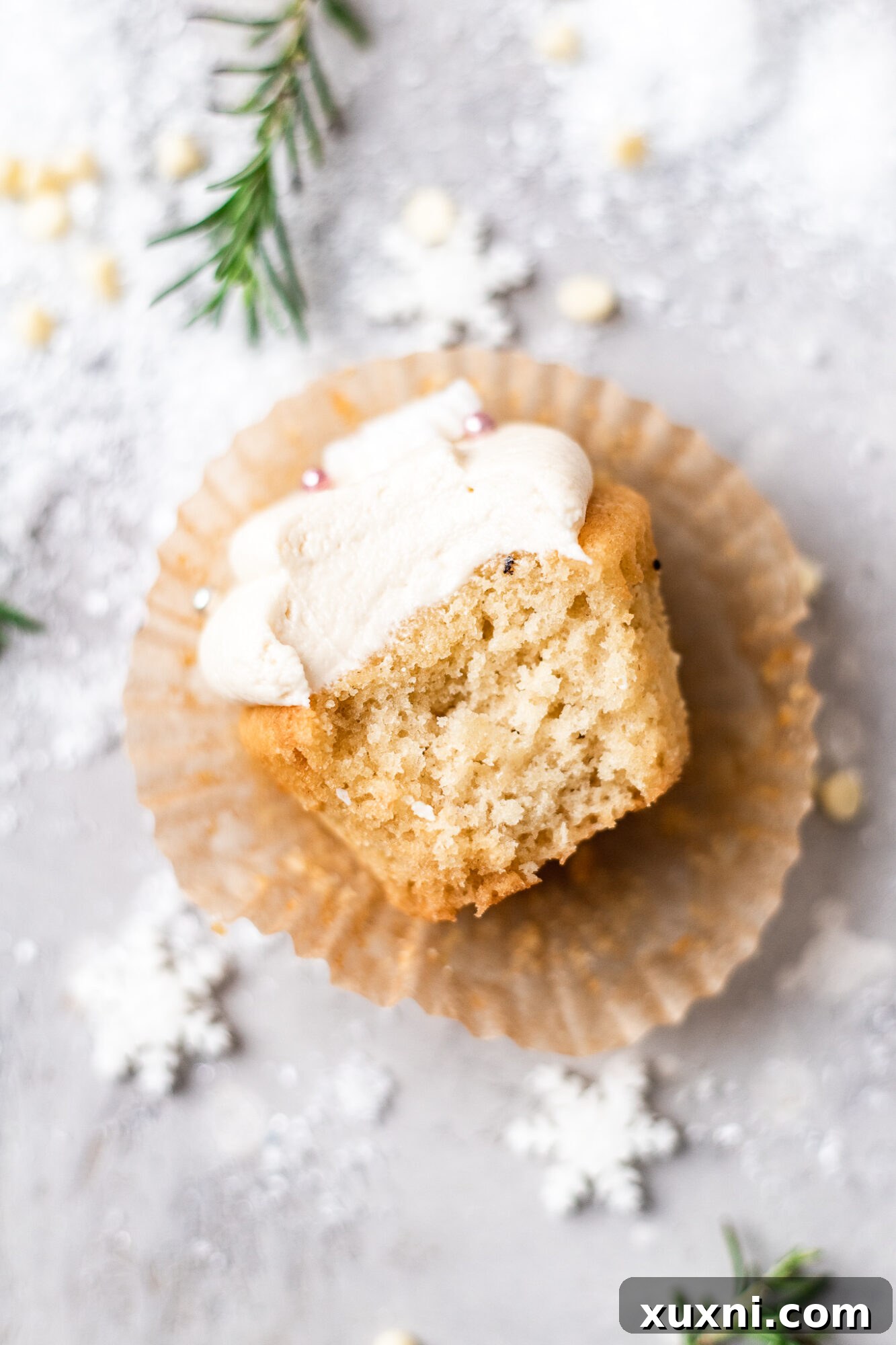A vegan Christmas cupcake with a bite taken out, showing the moist interior
