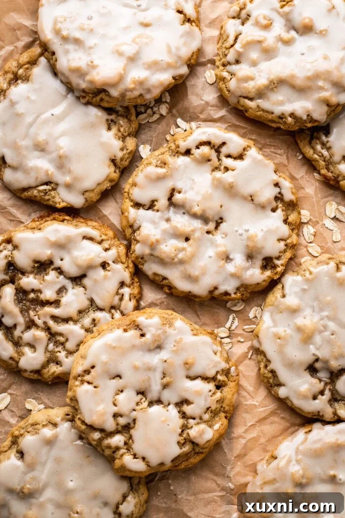 Delightfully chewy and soft vegan oatmeal cookies on parchment paper, freshly baked and ready for glazing