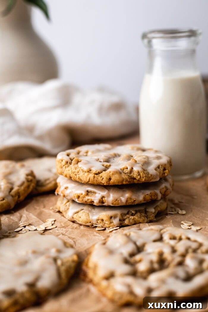 Stack of freshly baked and iced vegan oatmeal cookies, showcasing their inviting texture