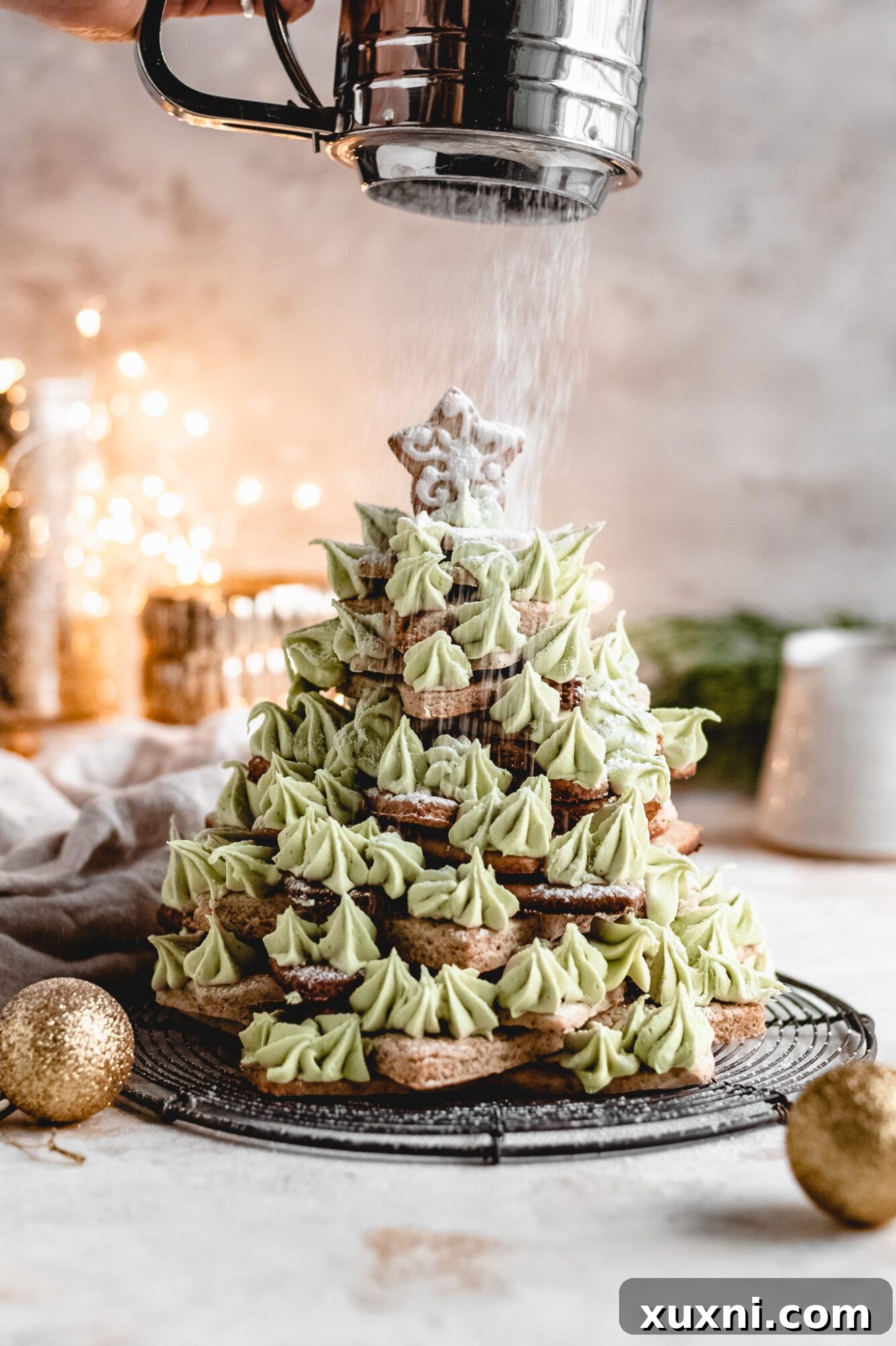 powdered sugar being sprinkled onto christmas cookie tree