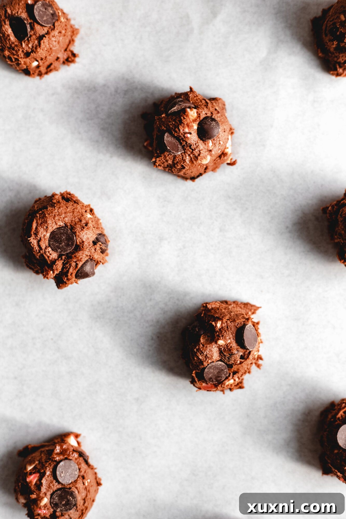 Raw vegan chocolate peppermint cookie dough balls on a baking sheet