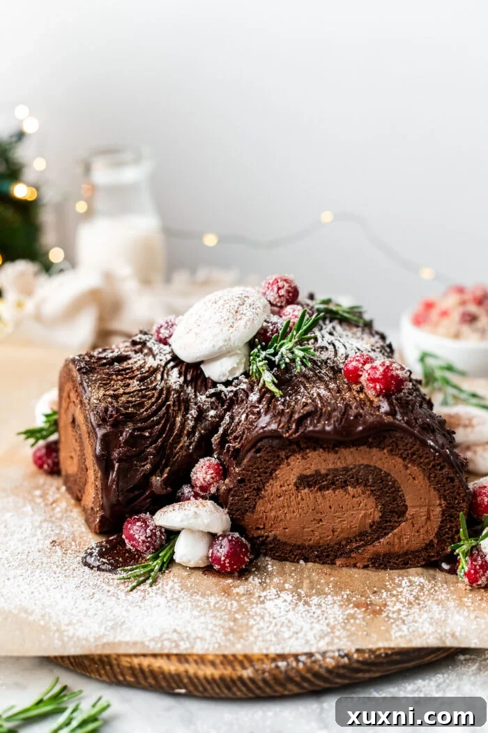 A close-up of the fully decorated Vegan Christmas Yule Log Cake, highlighting the meringue mushrooms.