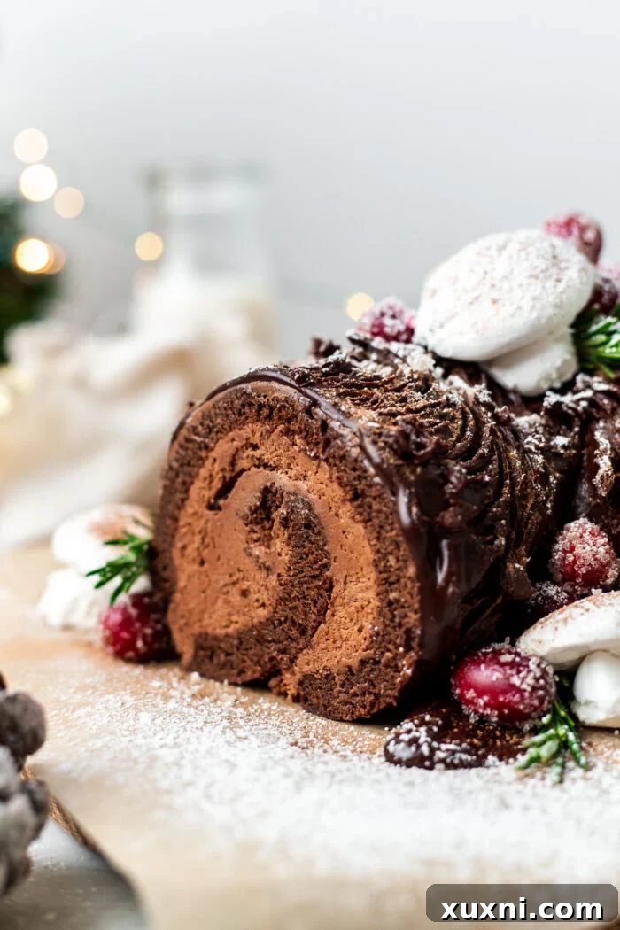 An inviting close-up of a slice of vegan Yule Log Cake, showcasing its delightful textures.