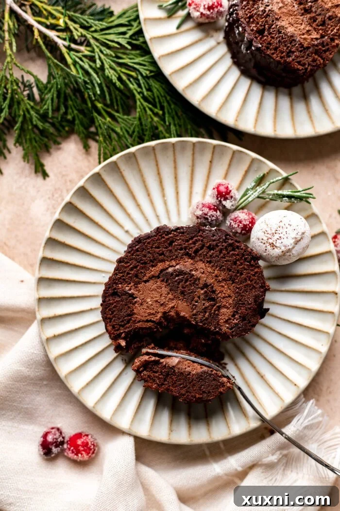 A perfectly portioned slice of vegan Yule Log Cake on a plate, ready to be enjoyed.