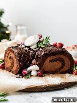Vegan Christmas Yule Log Cake (Bûche De Noël) on a wood board