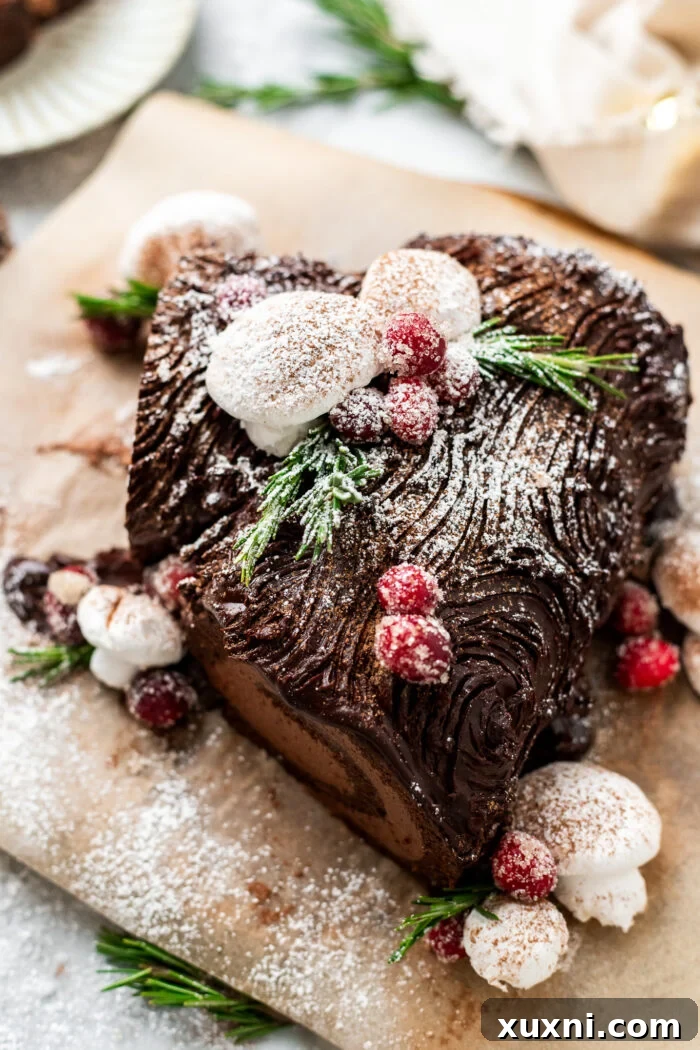 A stunning Vegan Christmas Yule Log Cake (Bûche De Noël) presented on a rustic wood board.
