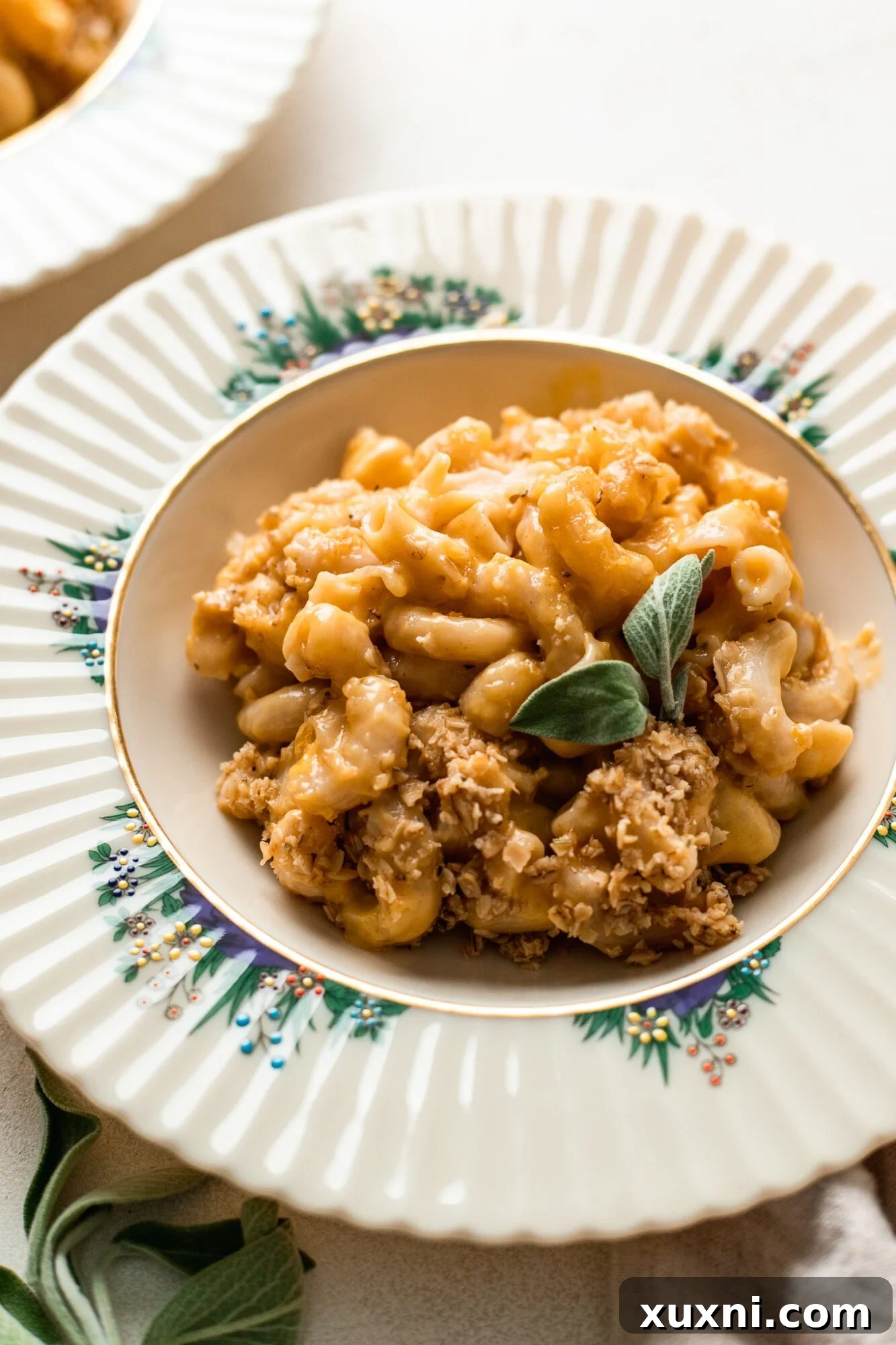 A vibrant plate of vegan mac and cheese, garnished with fresh herbs, showcasing its rich texture and color.