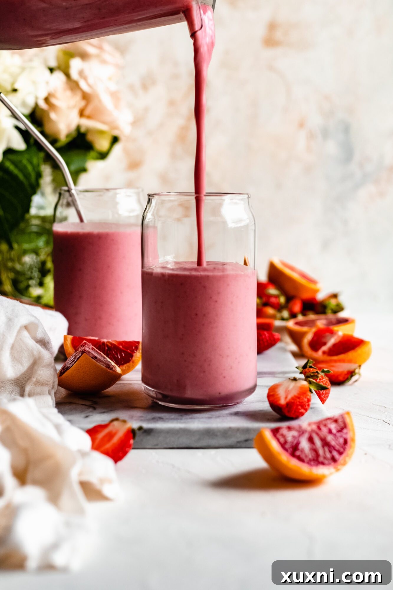Pouring the creamy Immune Boosting Strawberry Orange Smoothie into a glass