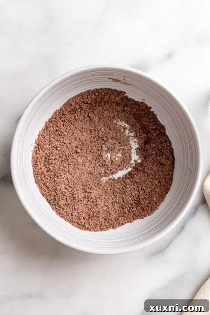Close-up of dry ingredients being whisked together in a bowl for small batch chocolate cupcakes.