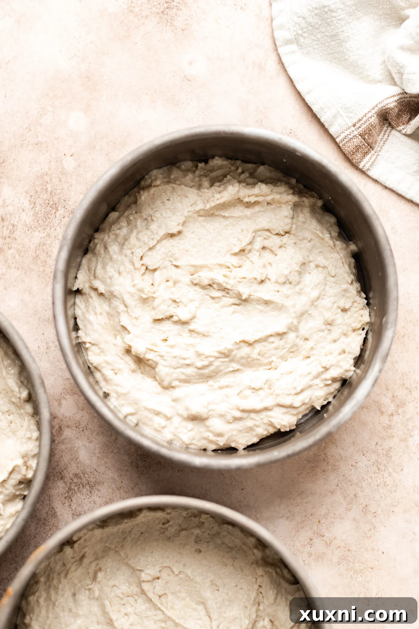 Unbaked vegan coconut cake batter in a pan, showcasing its smooth texture before going into the oven.