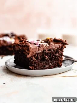 A delectable slice of vegan sheet cake on a white plate, highlighting its rich chocolate and frosting.