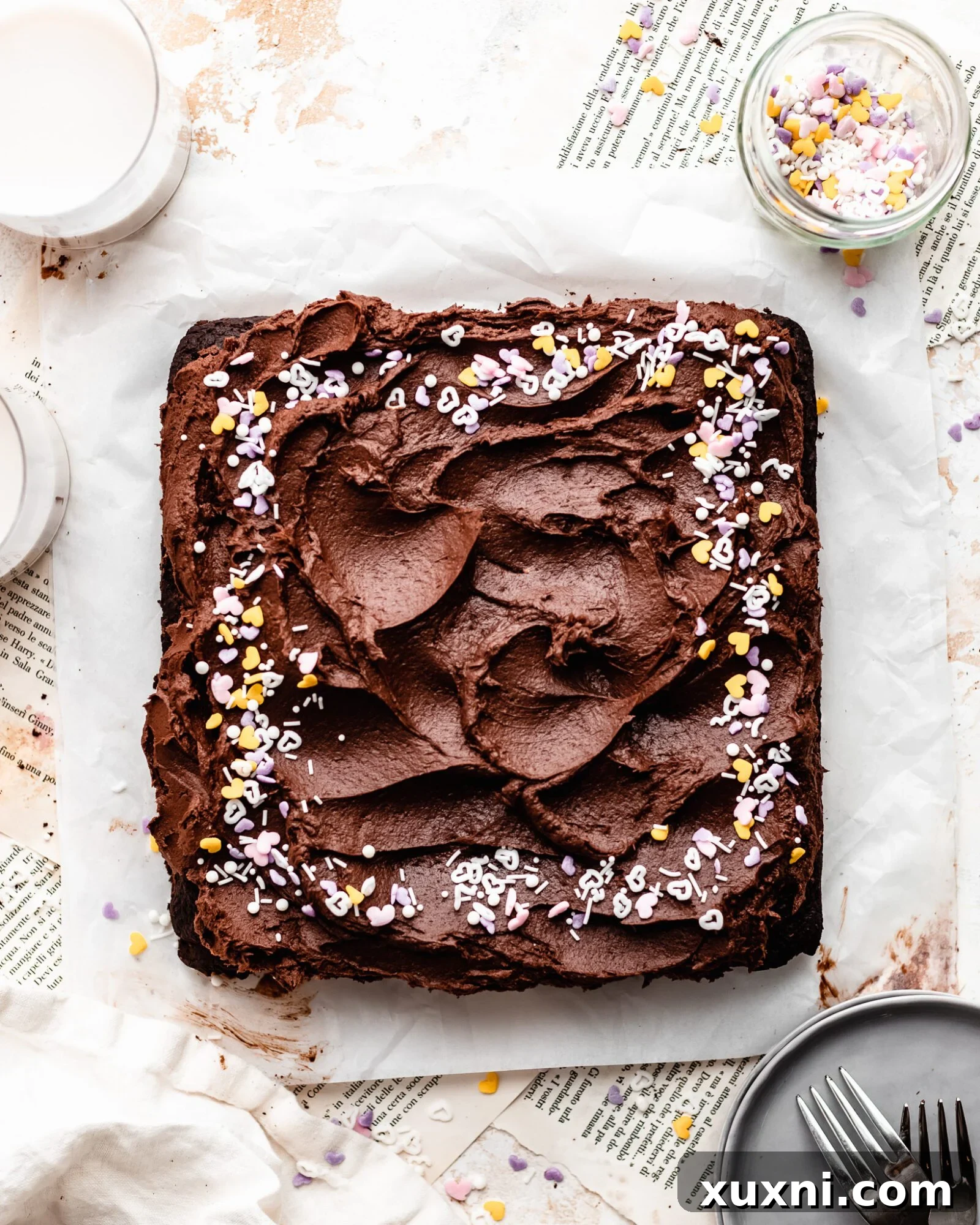 Close-up of a frosted vegan gluten-free chocolate cake with sprinkles, showcasing its inviting texture.