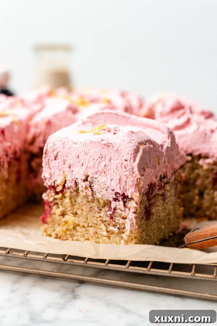 Zesty & Moist One-Bowl Vegan Raspberry Lemon Sheet Cake with Tangy Lemon Curd 11 Two slices of vegan raspberry lemon cake on white plates, one with a bite taken, showcasing its appealing texture.