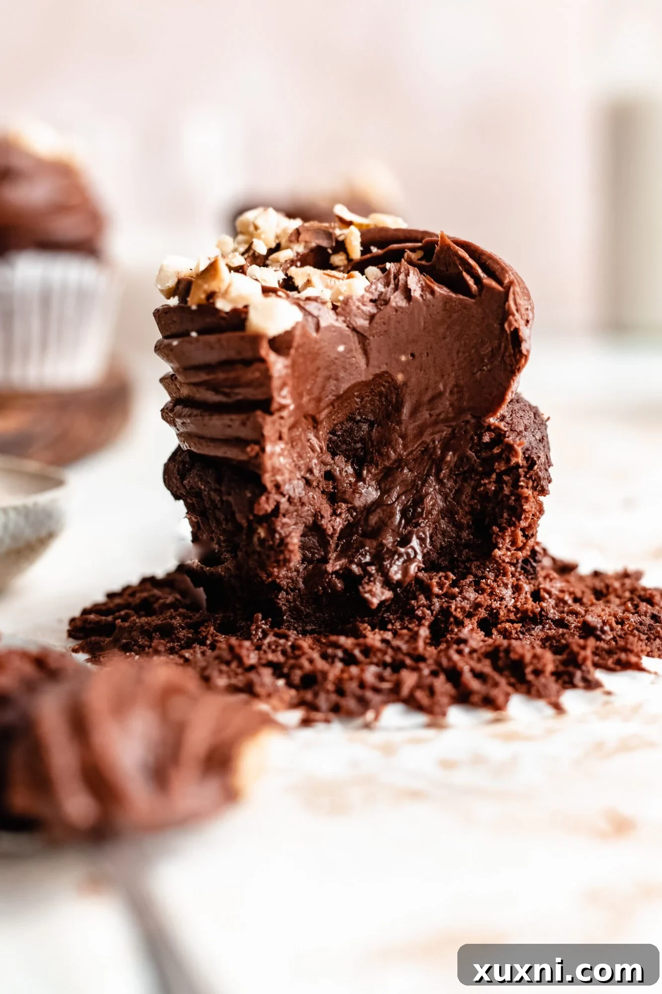 Scooping out the center of a vegan chocolate hazelnut cupcake to fill with spread