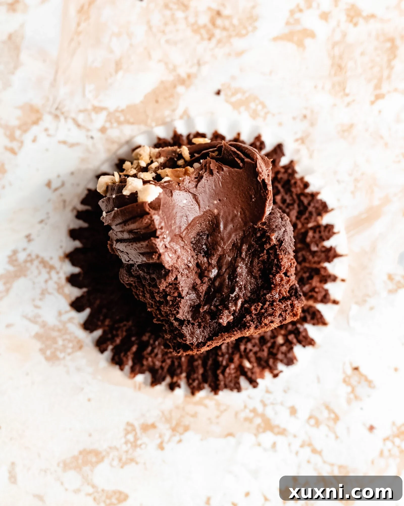 A half-eaten vegan Nutella cupcake showing the chocolate hazelnut filling