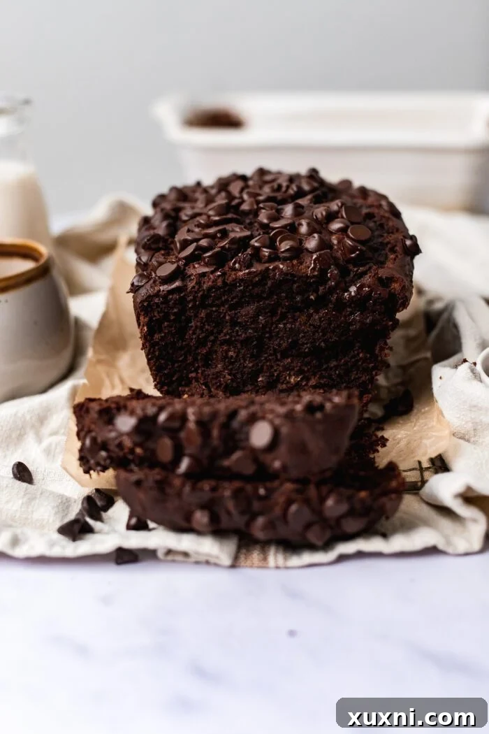 A freshly baked loaf of vegan chocolate banana bread placed on a elegant marble surface, showcasing its appealing crust and readiness to be served.