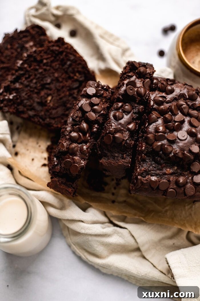 A beautifully sliced loaf of vegan chocolate banana bread, displaying its rich color and moist texture, ready for serving.