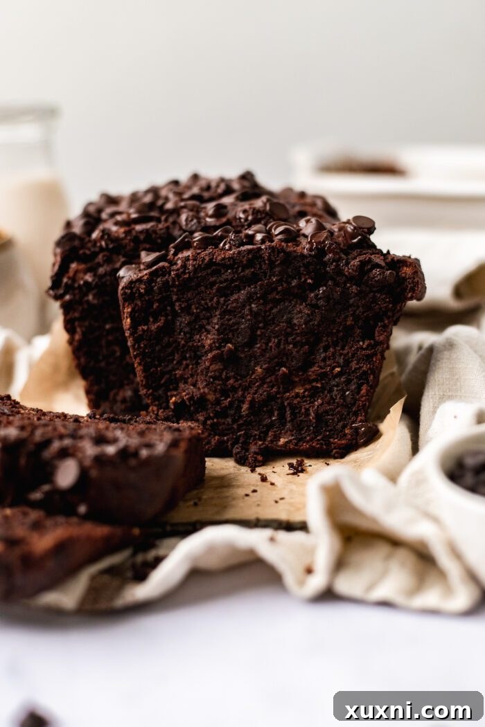Close-up of freshly sliced vegan chocolate banana bread, showcasing its moist, rich interior and generous distribution of chocolate chips, ready to be enjoyed.