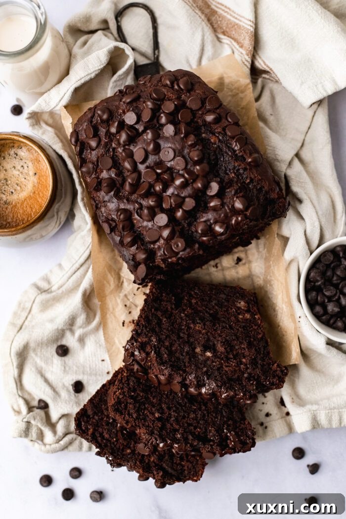 A delectable slice of vegan chocolate banana bread, perfectly baked and served alongside a warm cup of coffee, inviting you to savor its rich flavors.