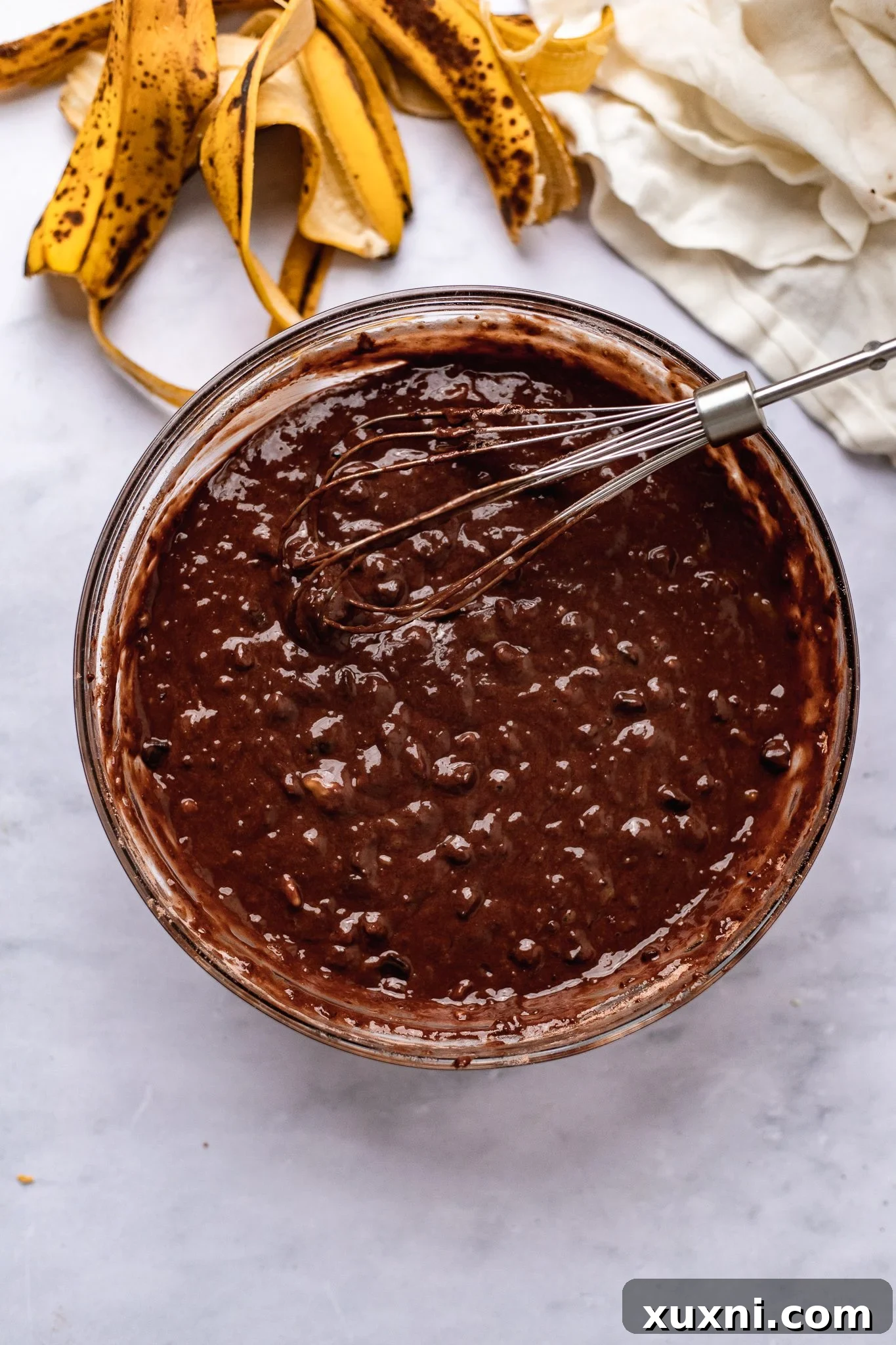 A bowl containing the fully mixed vegan chocolate banana bread batter, smooth and ready to be poured into the loaf pan.