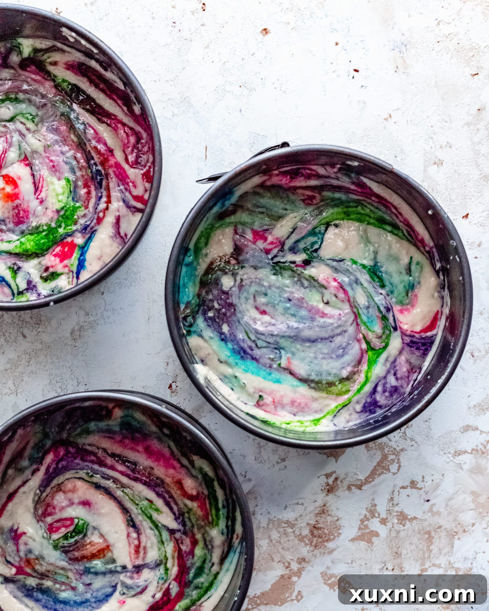 Cake batter with drops of vegan food coloring for rainbow swirl