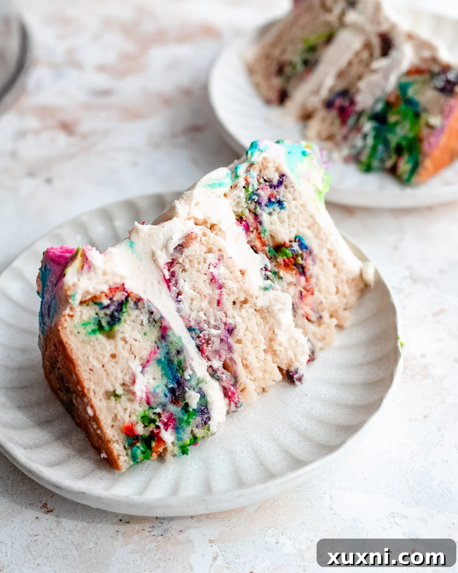 A vibrant slice of vegan rainbow swirl cake with buttercream