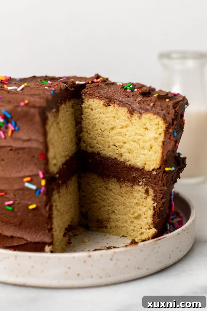 A slice of vegan birthday cake on a white plate with a fork